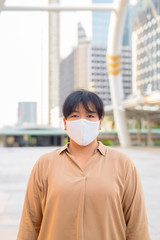 Overweight Asian woman with mask at skywalk bridge
