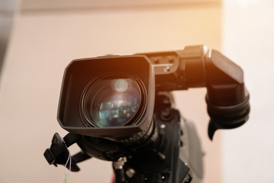 Television Camera Lens, Film Of Video Movie Recording Films Shooting Of Grand Opening In Conference Hall Live Streming For Presentation With Bokeh Light Background. Media Production Concept