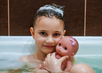 Girl 5 years old in the bathroom with foam. Girl washes her head in the bathroom