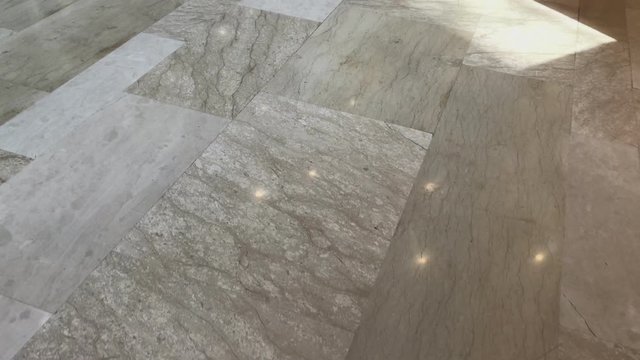 Walking through the luxury marble in the building. Elegant reflections and light reflected from the smooth ground. Part of the interior design. Going on the road made with marble. No people view.