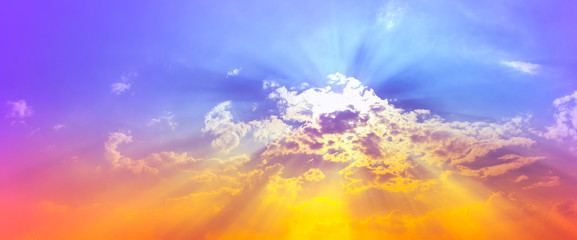 orange yellow and purple red color light and sun beam in purple blue sky with clouds