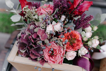 Floral arrangement or wedding bouquet of red pomegranate flowers with pink and white roses,...