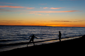 Skipping stones on the beach at sunset