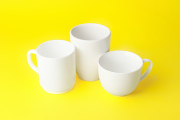 Blank cups on color background