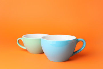 Blank cups on color background