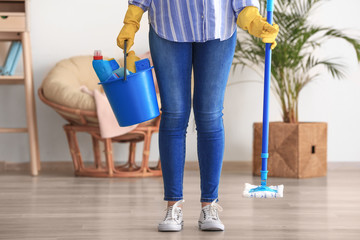 Woman with cleaning supplies in room