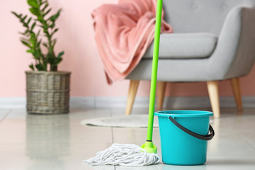 Mop and bucket on floor in room