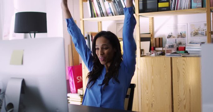 Excited African American woman celebrate big success in work career after approval of project proposal. Female architect feel happiness and excitement receive good news. Slow motion on 4K RED camera
