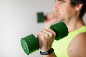 Fototapeta na wymiar Sporty, strong, professional, successful, athletic person calling to take exercise, holding weights in hand, showing dumbbells to the camera, 