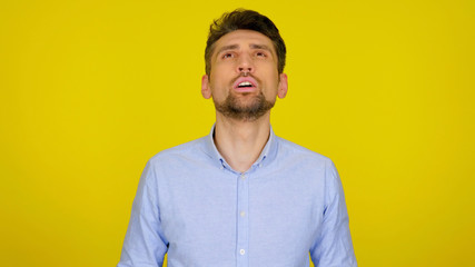 Bearded man in a blue shirt asks the Almighty for help. The guy raised his head up and prays to...
