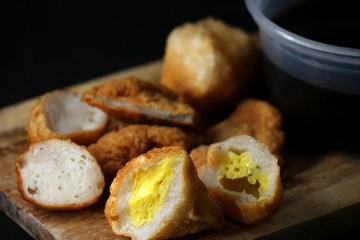 Delicious pempek palembang and cuko sauce on a wooden board. Indonesian traditional fish cakes, perfect for food blogs & menus.