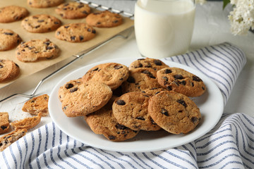 Composition with chip cookies and milk on white table