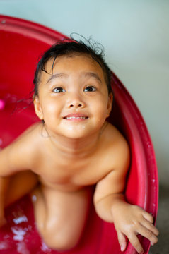 An Asian girl playing bathing has a happy face.