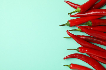 Chilli peppers on mint background, top view