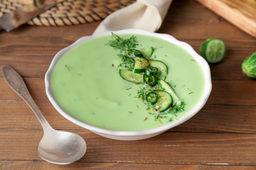 Bowl with cold cucumber soup on table
