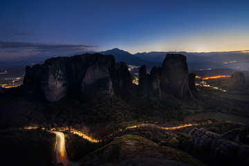 Meteora rocks at evening night time with light from city