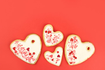 Hand made cookie hearts on a red background, copy space