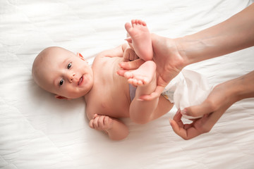 Newborn baby getting a diaper change: mom wiping baby's bottom with baby wipe. emotions of newborn baby. Concept Hygiene cleaning wipe, pure, clean