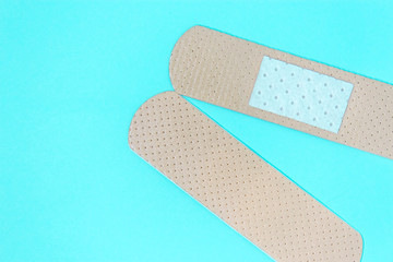 two skin color medicine adhesive healing bandage layout on blue background. wound healing patch concept