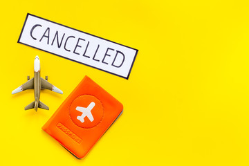 Cancelled flight. Airplane and passport on yellow background top view copy space