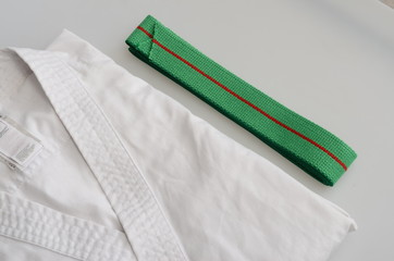 karate equipment : green belt, kimono on light background - 346393113
