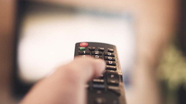 4K shallow depth of field Remote control with blurred Television Background. Concept for TV streaming and smart home remote control.
