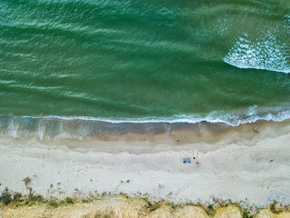 Aerial view of sandy beach and sea with waves
