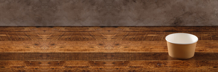 Big brown paper plate isolated on wooden background. Eco-friendly disposable food packaging. Preserving nature and recycling concept. Banner.