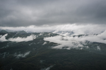 Mountain landscape covered with fog and clouds