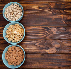 Different types of nuts in bowls. Almonds, pistachios, cashews Flatly