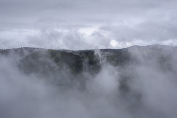 Mountain landscape covered with fog and clouds