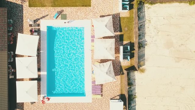 Top view of the pool. Rectangular pool and umbrellas with loungers