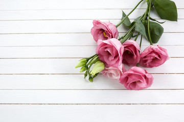 Pink eustoma flowers on wooden background in vintage style. Romantic wedding background. Top view.