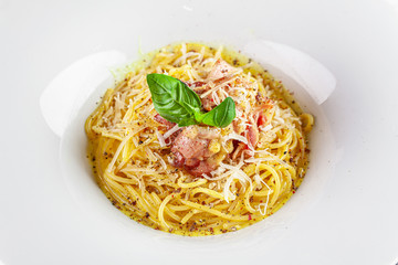 Italian Cuisine. Carbanara pasta with bacon and parmesan. Beautiful serving dish in a restaurant in a white plate. background image, copy space text