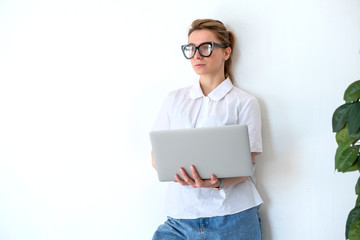 girl works at home standing near a white wall