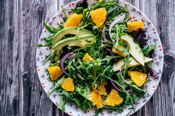 Assiette de salade verte avec des tranches d'avocat et d'orange - Alimentation fraiche et saine