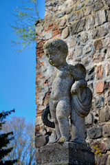 Fototapeta na wymiar Steinerne Putte am Grab von Ernst und Marie von Mendelssohn-Bartholdy vor der denkmalgeschützten Dorfkirche in Börnicke