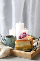 Cup of tea and delicious cheesecake on grey table