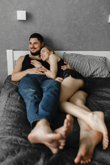 Woman and her man lying on the bed and laughing. Stay home