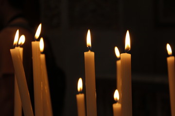 Lit candles in church with dark background