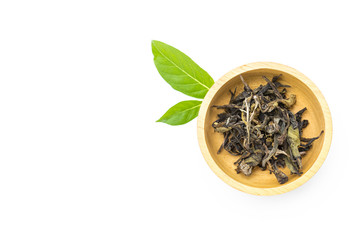 Dry tea leaves in round wooden bowl on white background, organic tea, healthy drink