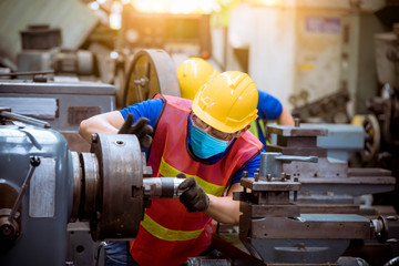 Industry worker wearing glass, ear phone and safety uniform used Vernier caliper to measure the...