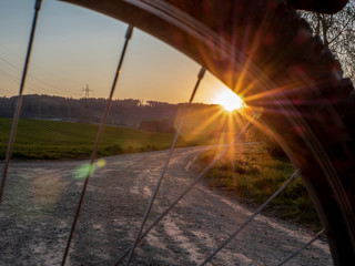 A bike on a dirt road on the border of a lake in Switzerland in Spring at sunset