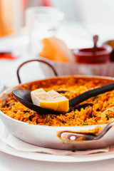Spanish Seafood Paella with mussels, shrimps and a piece of lemon. in a steel paella pan. Canary islands cousine in a small family restaurant.