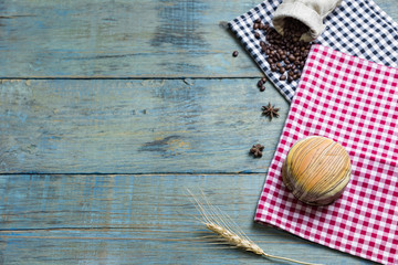fresh bread put on red.scottish pattern fabric with sack of roasted coffee beans , grains in wooden spoon on old wooden table background.Top view with copy space and selective focus.