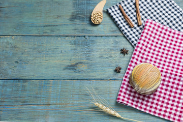 fresh bread put on red.scottish pattern fabric with grains in wooden spoon on old wooden table background.Top view with copy space and selective focus.