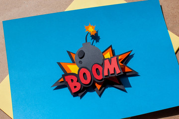Paper cutting comic speech bubble on blue background. Boom. Bomb. 