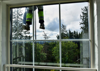 Haanja / Vorumaa, Estonia - The legs of an industrial climber (window washer) are visible outside the observation deck window on the highest Baltic mountain Suur-Munamagi.