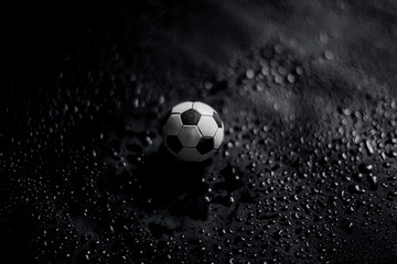 Fototapeta premium Soccer ball on a black background with water drops. 