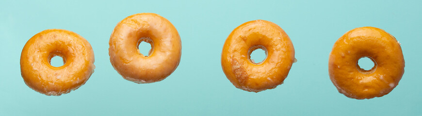 Obraz na płótnie Canvas Falling donuts in a glaze on a blue background